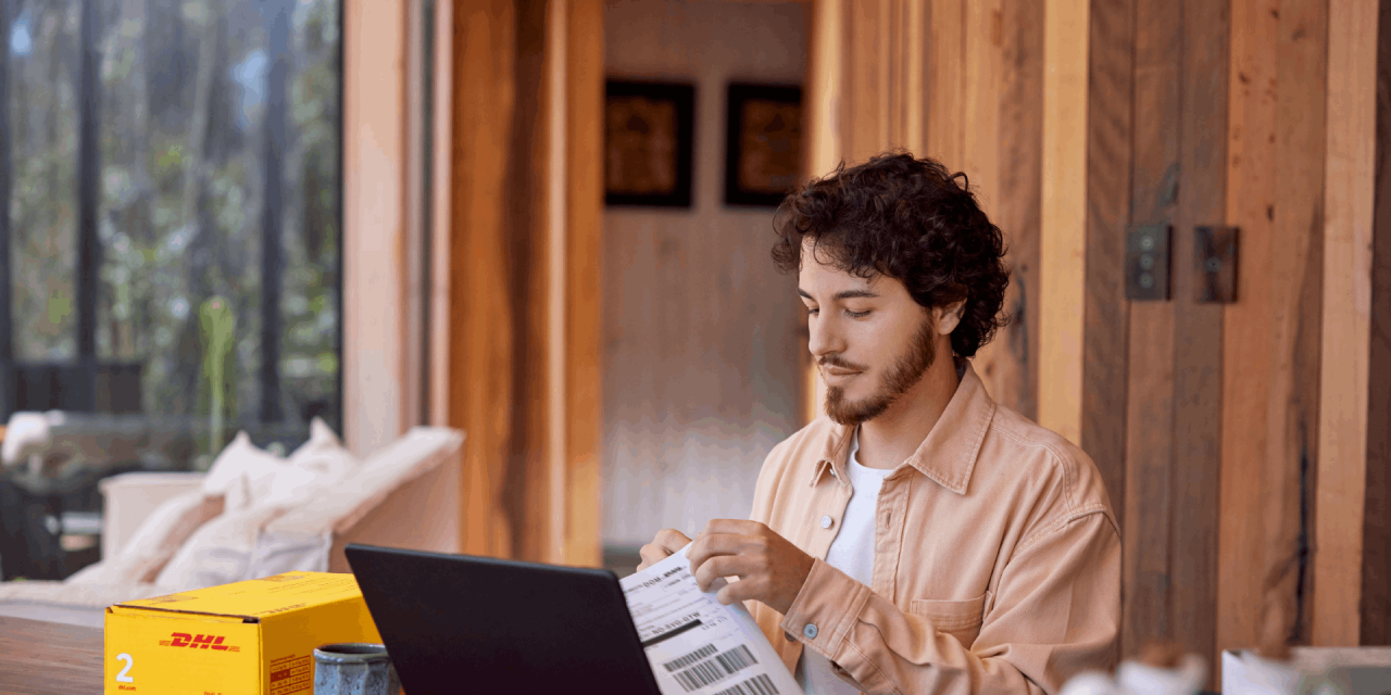 A person opening a package at their desk