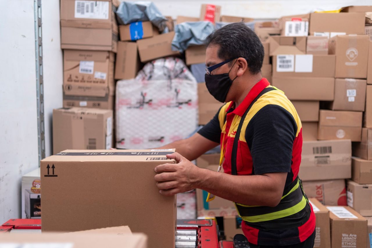 dhl employee checking different types of corrugated and cardboard boxes
