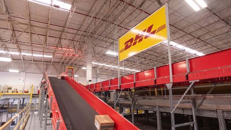 dhl express courier handing off a package to a happy customer