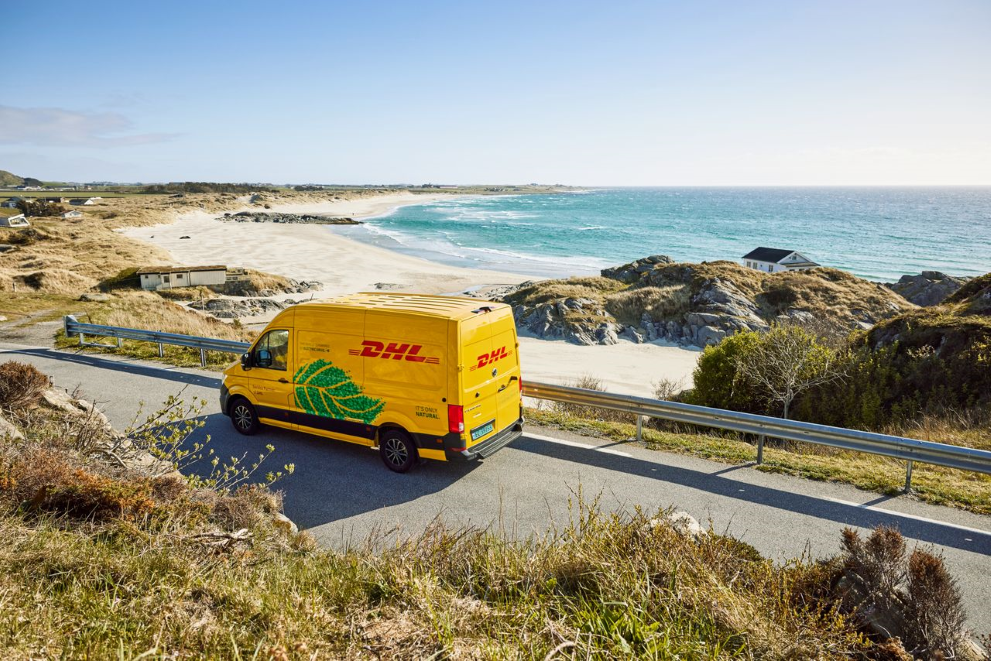 a DHL courier van drives by the sea
