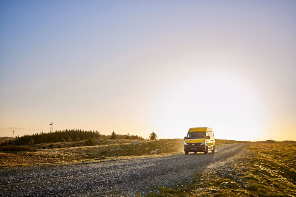 a DHL courier van drives across a landscape