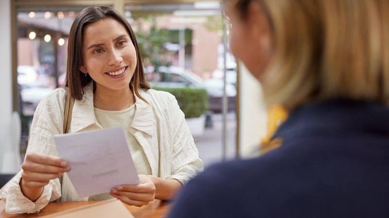 woman holds a document at a DHL Service Point counter