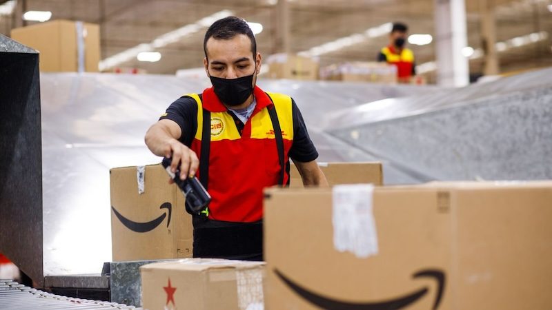DHL employee inspecting boxes filled with Pakistani footwear