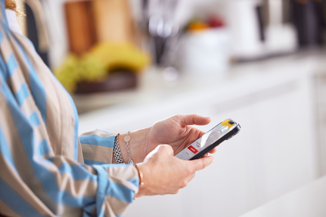 woman using mydhl plus on her phone to ship parcel