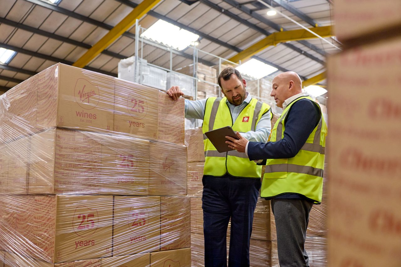 Two workers inspecting a bulk consolidated shipment in a warehouse. 
