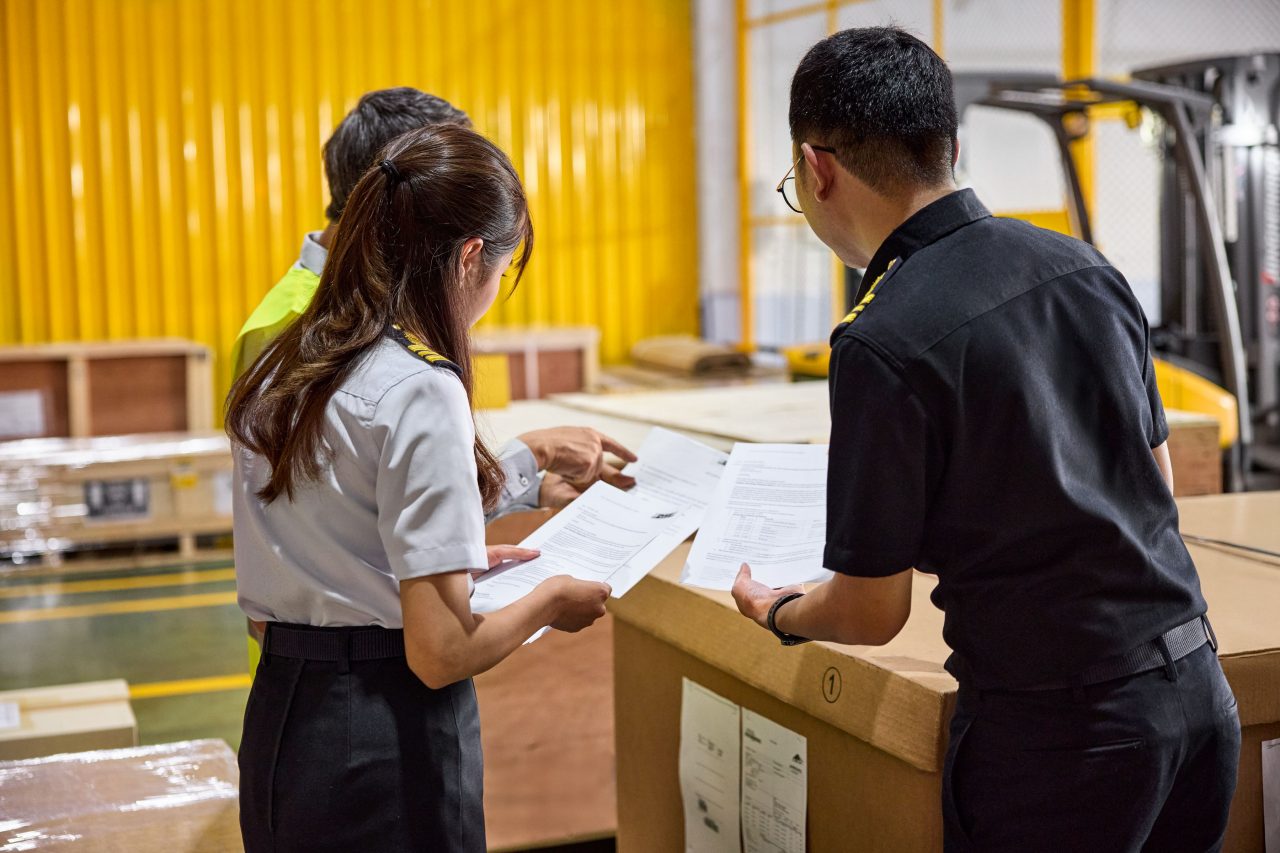 A customs inspector goes over paperwork in a DHL facility. 